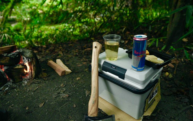Portable cooler with cold drinks at a campsite