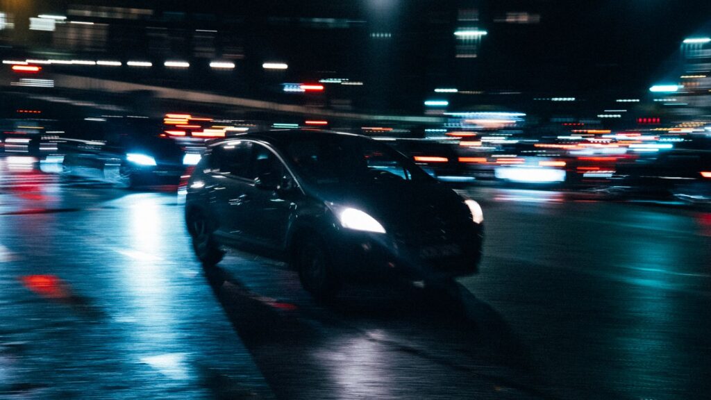 Car driving on a city street at night