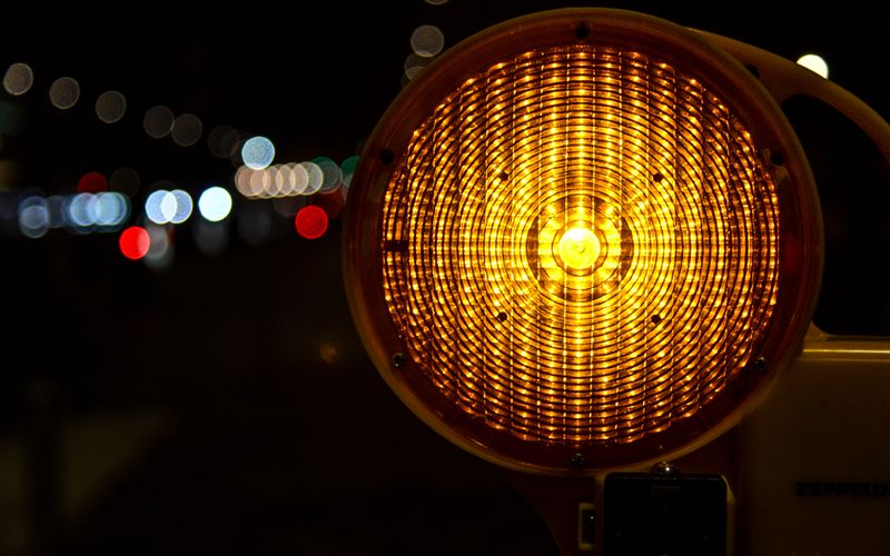 Amber roadside warning light glowing at night